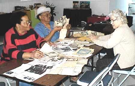 Ladies going over the newspaper clippings